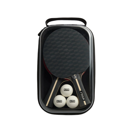 Ping pong paddle and balls in a black carrying case on a light gray background