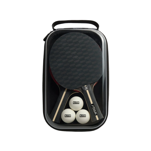 Ping pong paddle and balls in a black carrying case on a light gray background